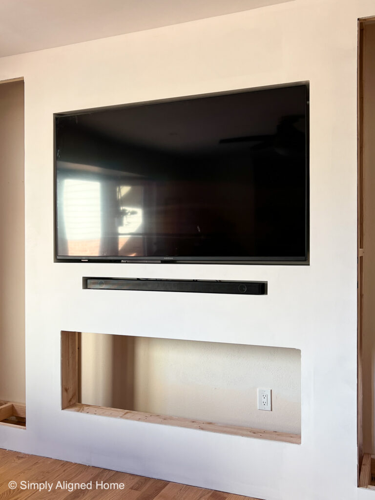 https://simplyalignedhome.com/wp-content/uploads/2022/12/Simply-Aligned-Home-Electric-Fireplace-Built-In-with-TV-and-Soundbar-Installed-768x1024.jpg