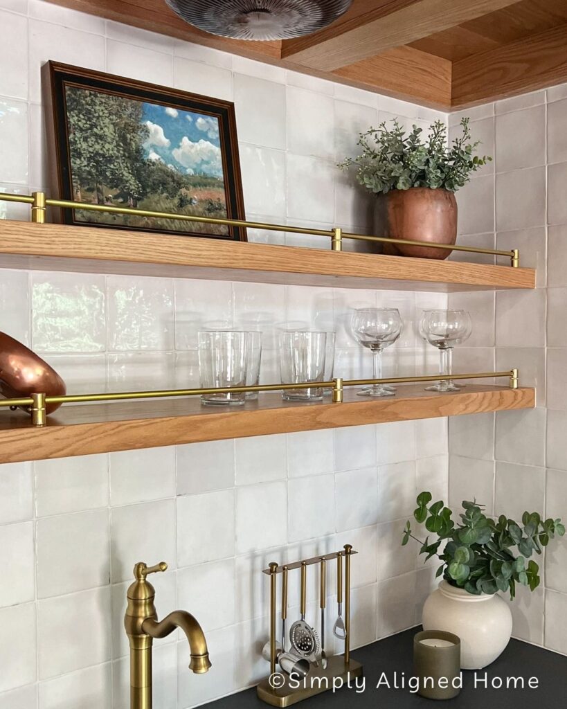 Brass railing on thin floating shelves. 