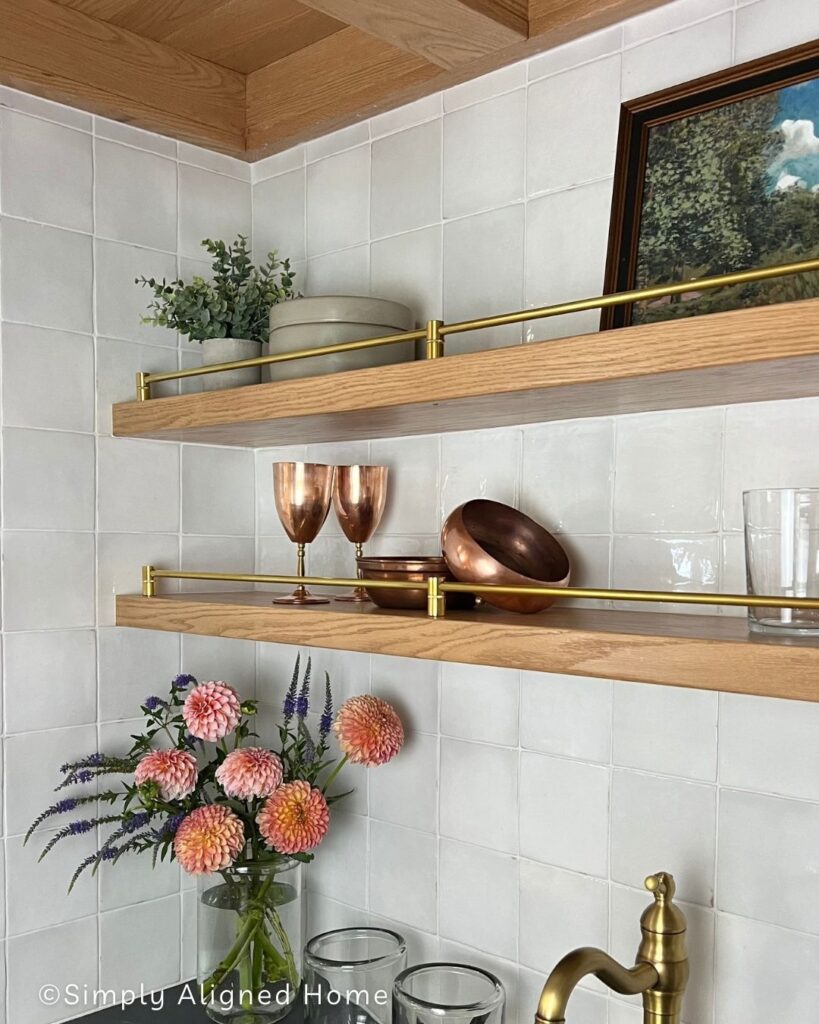 Thin floating shelves with brass railing.