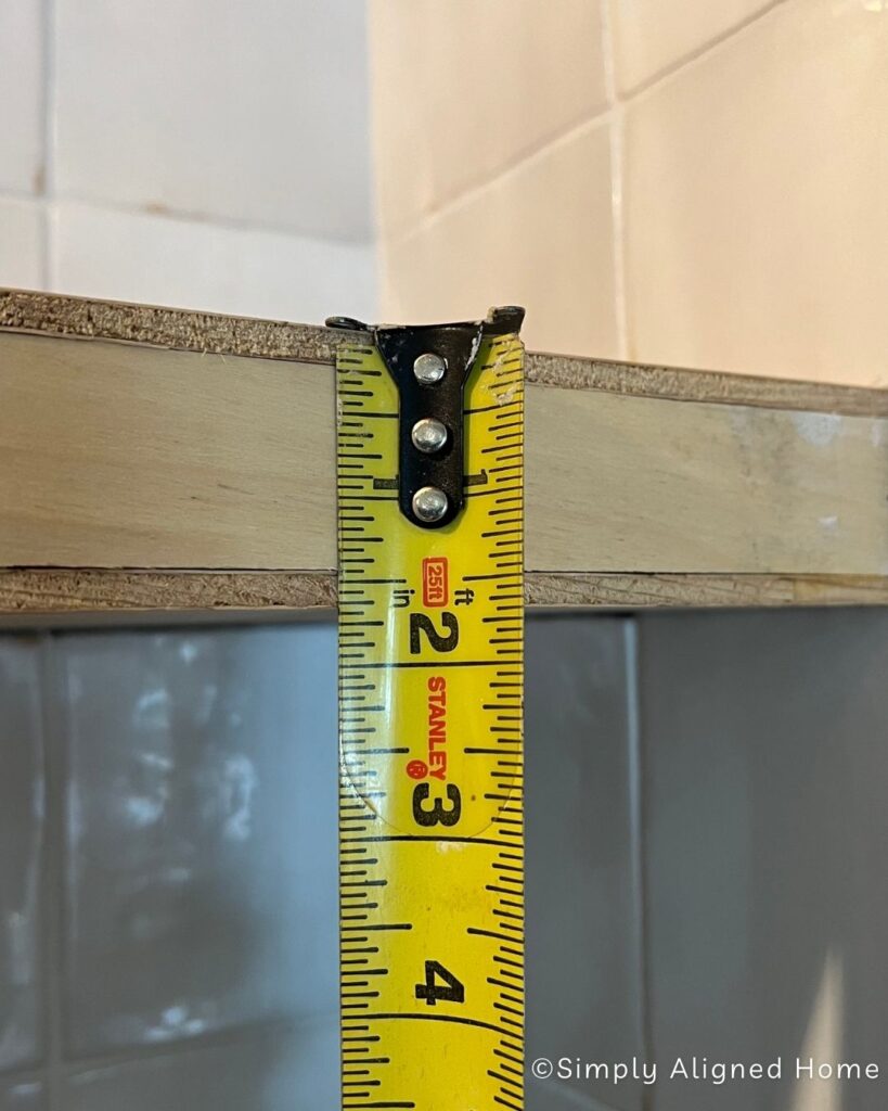Measuring how thin the shelf is. 